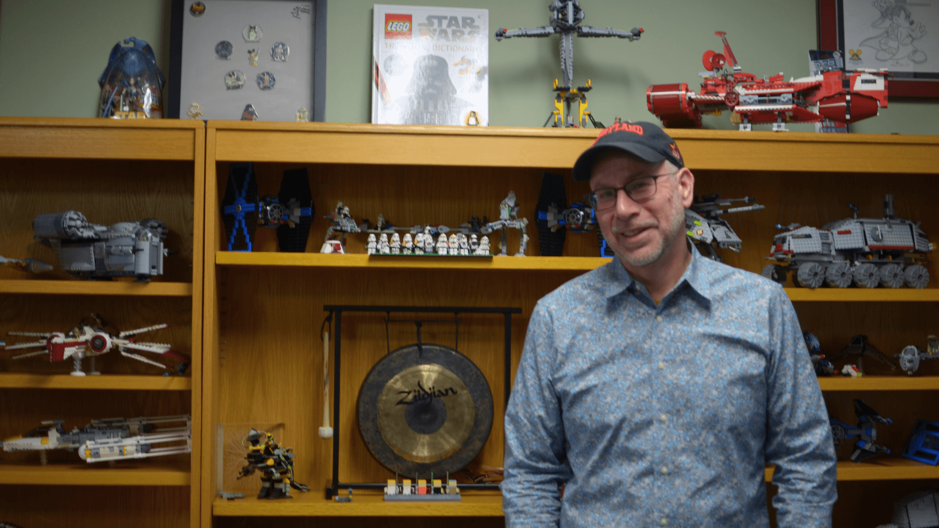 Bryan Quinn stands in his office in front of a wall filled with Star Wars Legos