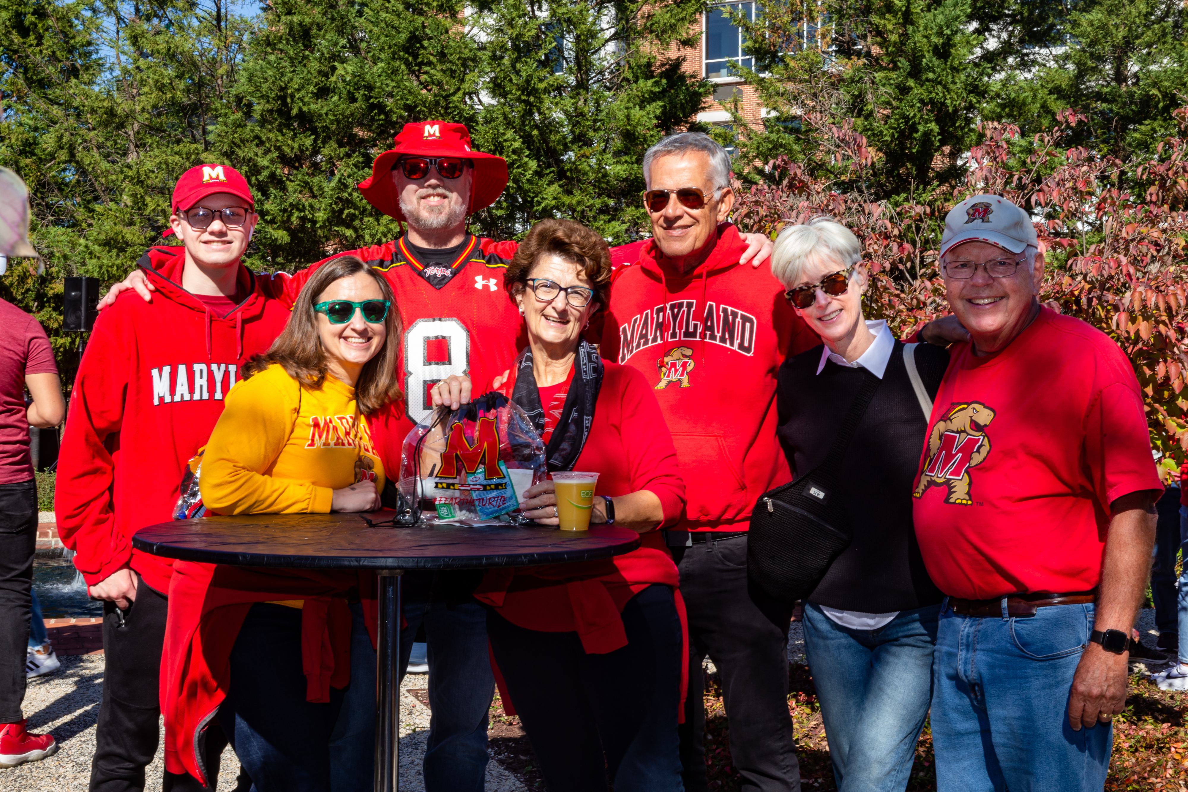 Terps posing for a photo at the UMD Alumni Association Homecoming Tailgate