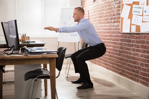 Man Squatting at Desk