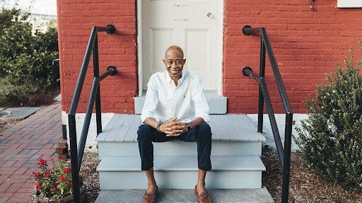 UMD graduate Danilo de Sousa Nhantumbo sitting on the stairs in front of a house