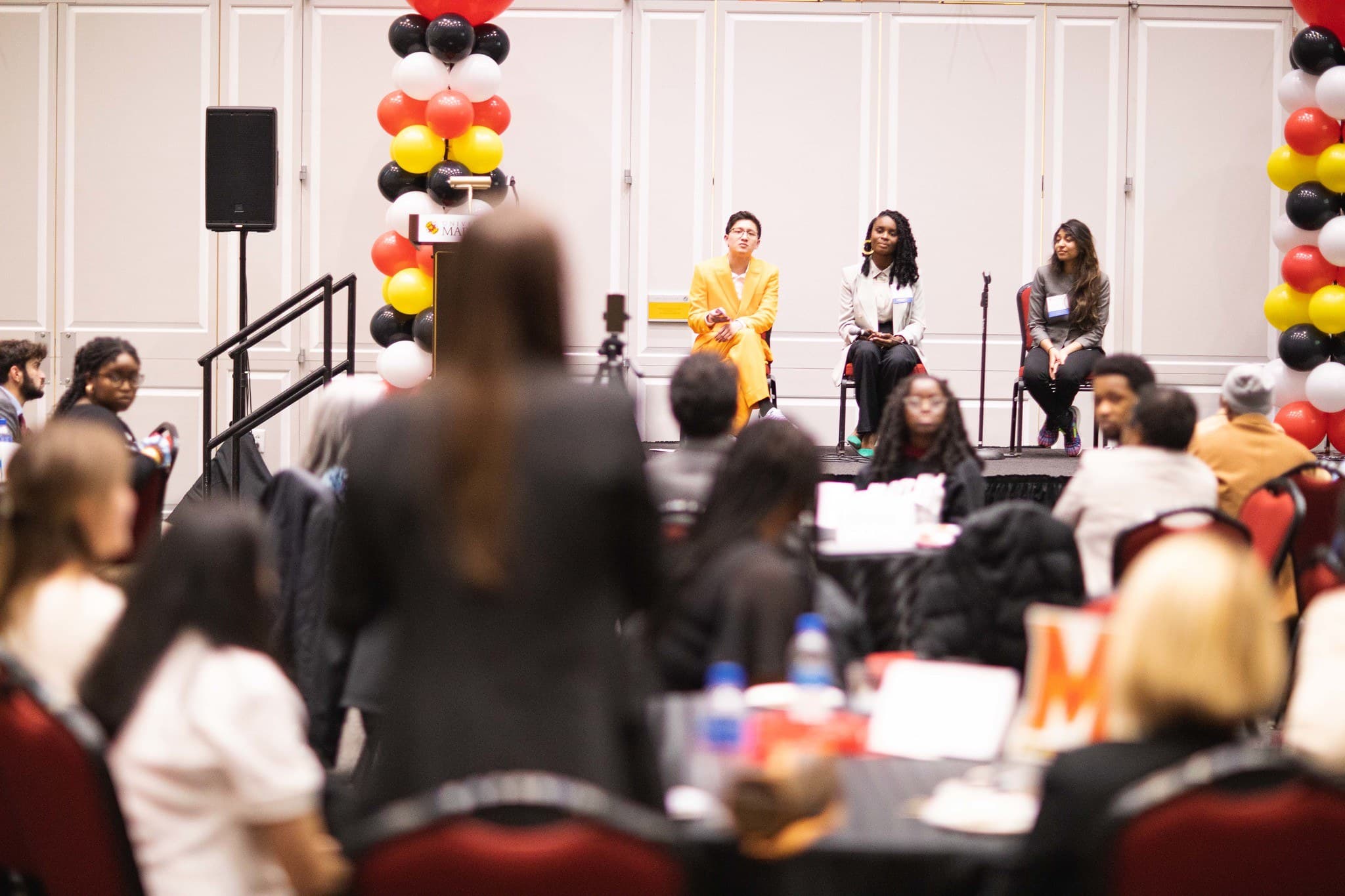Panel of young alumni speaking while an audience member asks a question