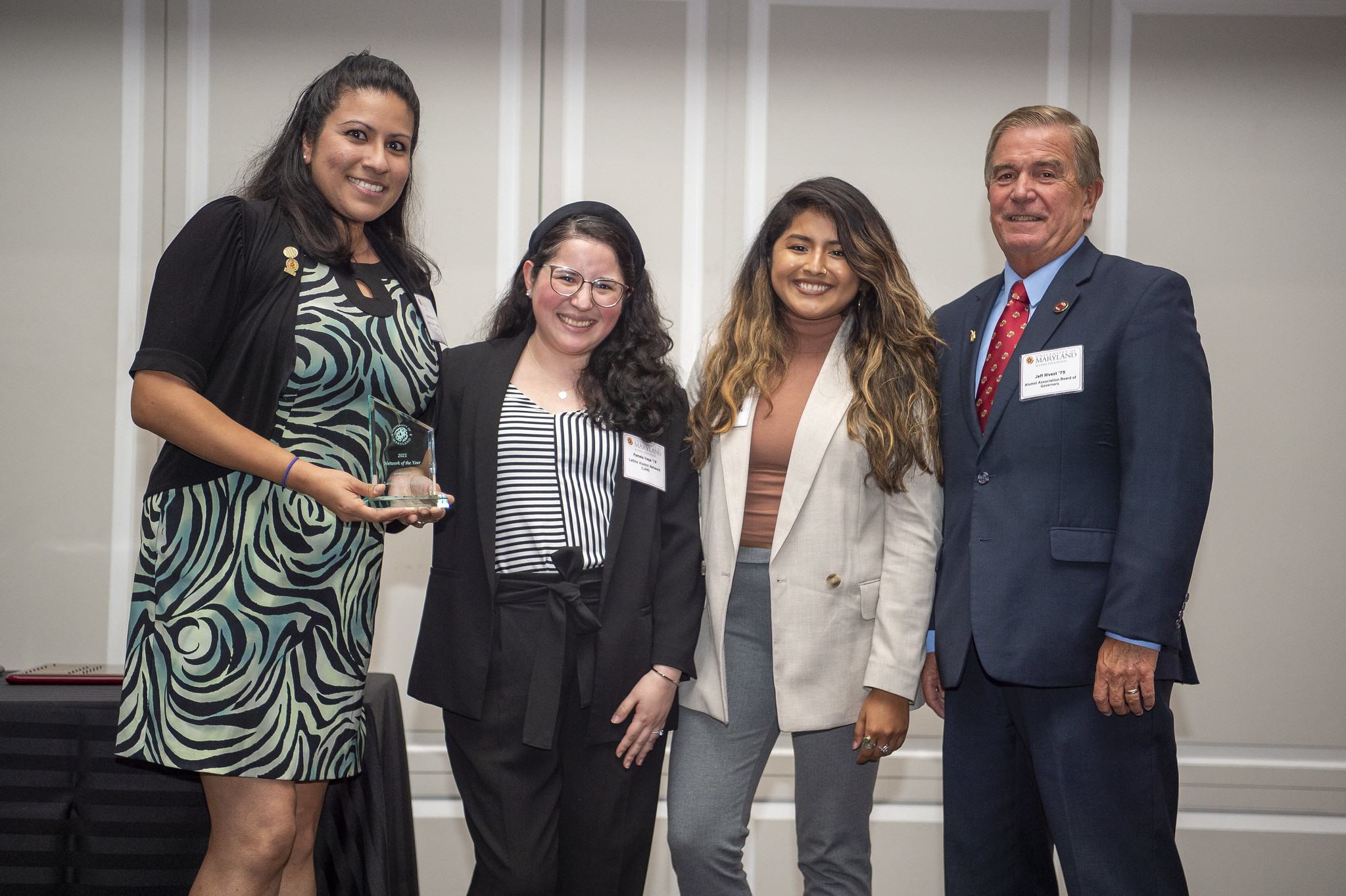 Group standing together on stage after receiving an award