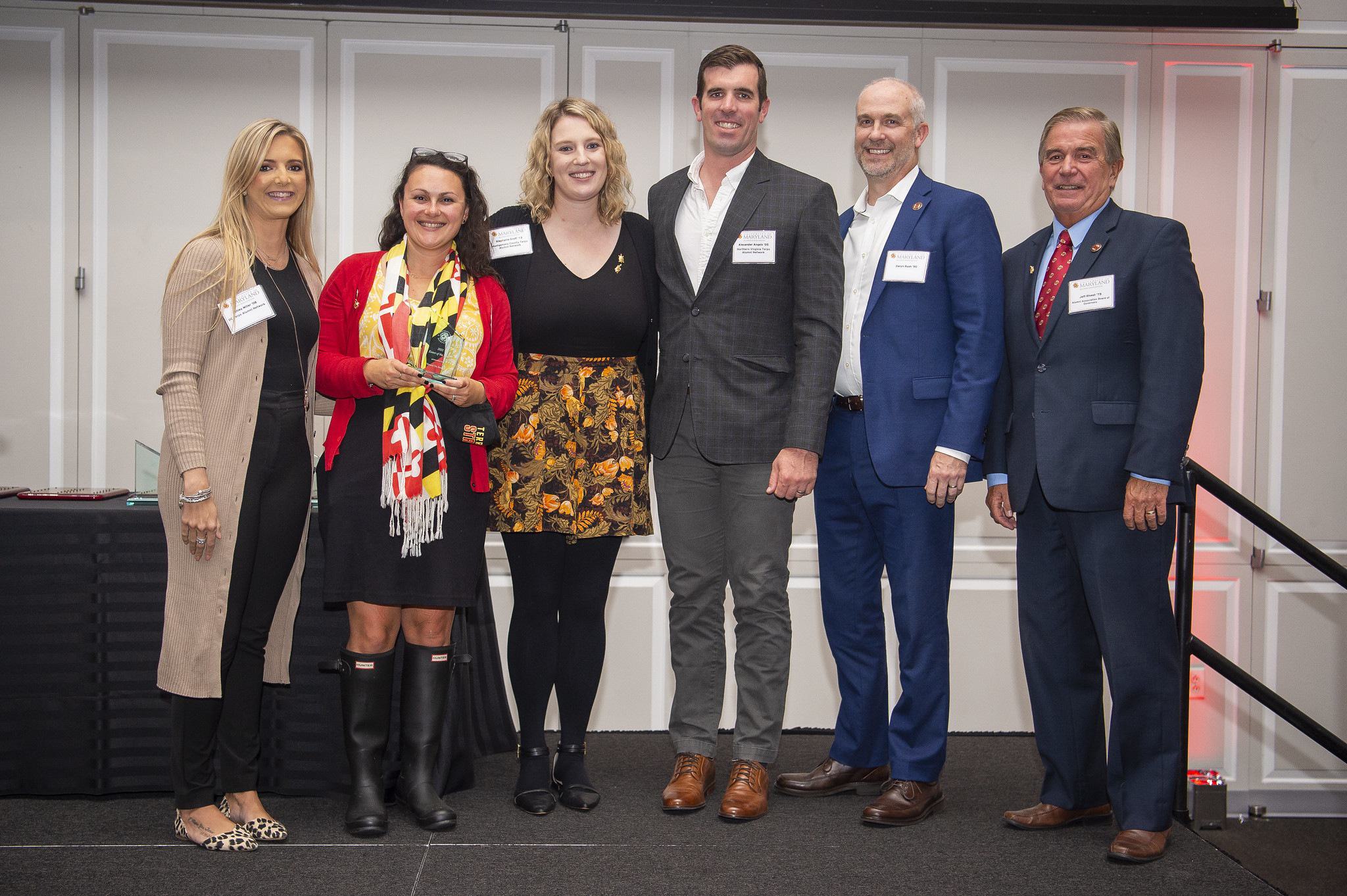 Group standing together on stage after receiving an award