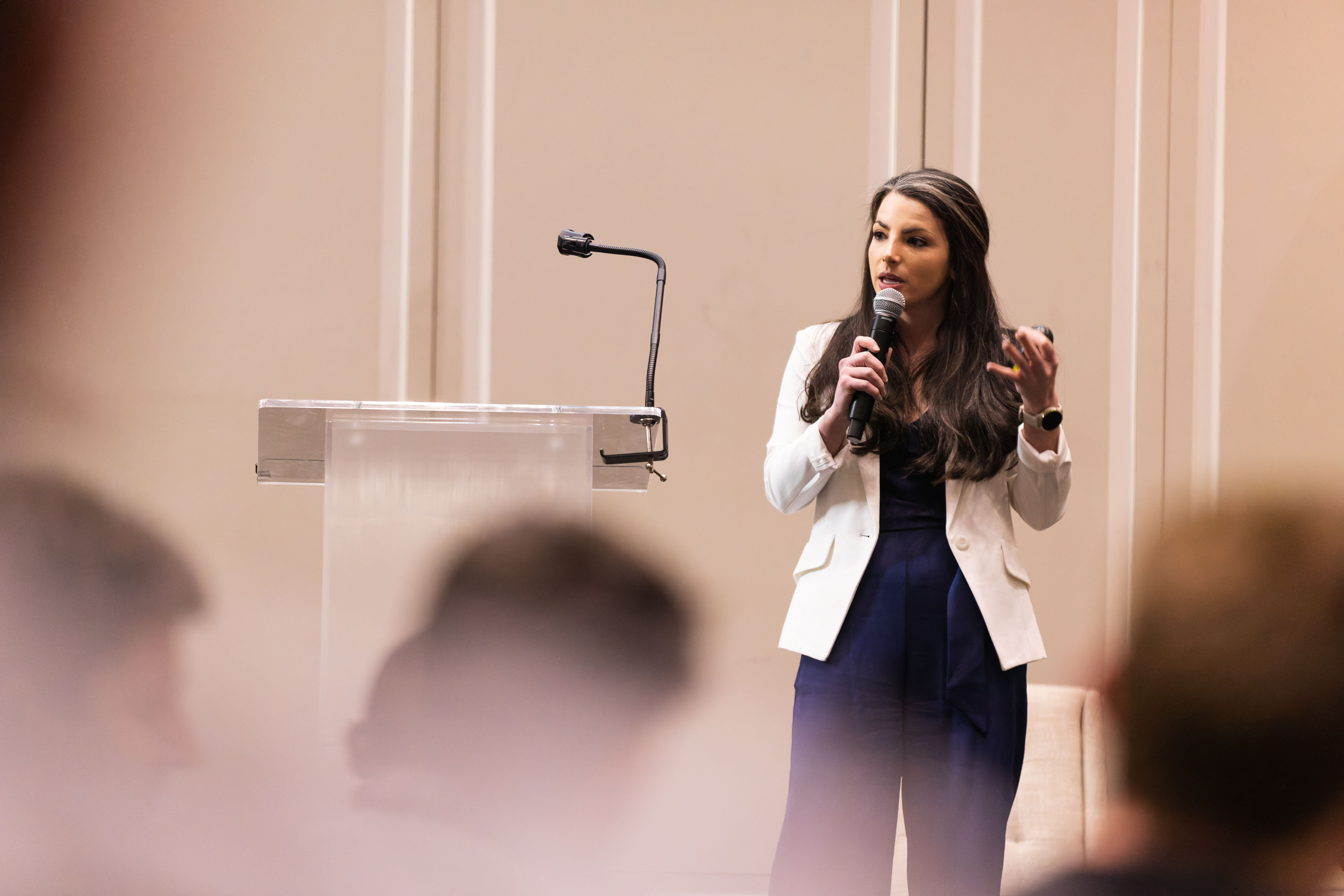 Rachel Lipman '15 speaking in front of a large crowd gathered at the Riggs Alumni Center in College Park MD.