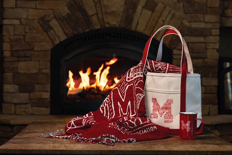 Maryland Icon tote, mug and blanket in front of a fireplace