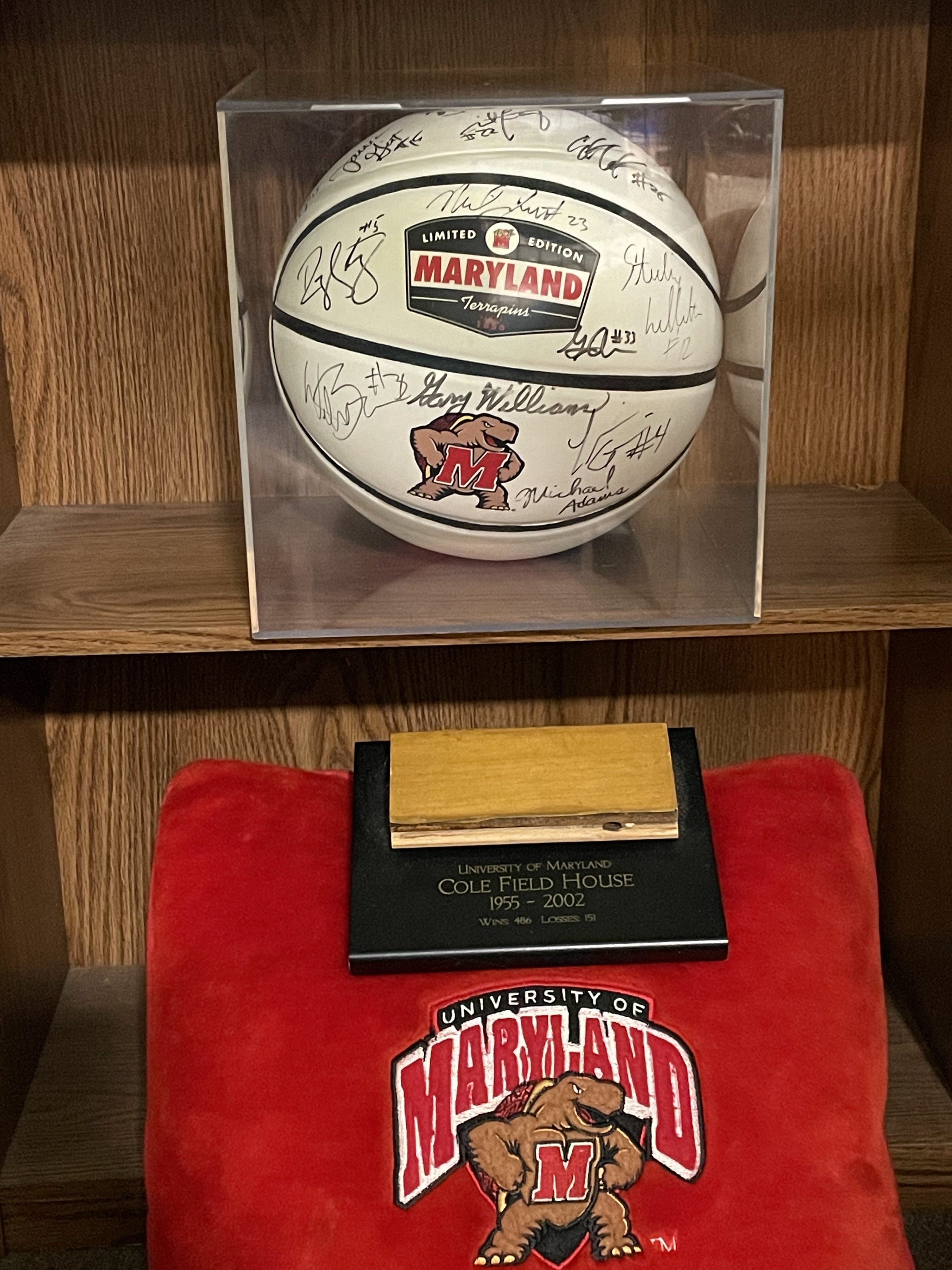 This basketball, signed by Gary Williams and others, and a piece of the old Cole Field House floor are just two samples of the Terrapin sports memorabilia that Alissa Arford '94, MBA '10 has on display at home.