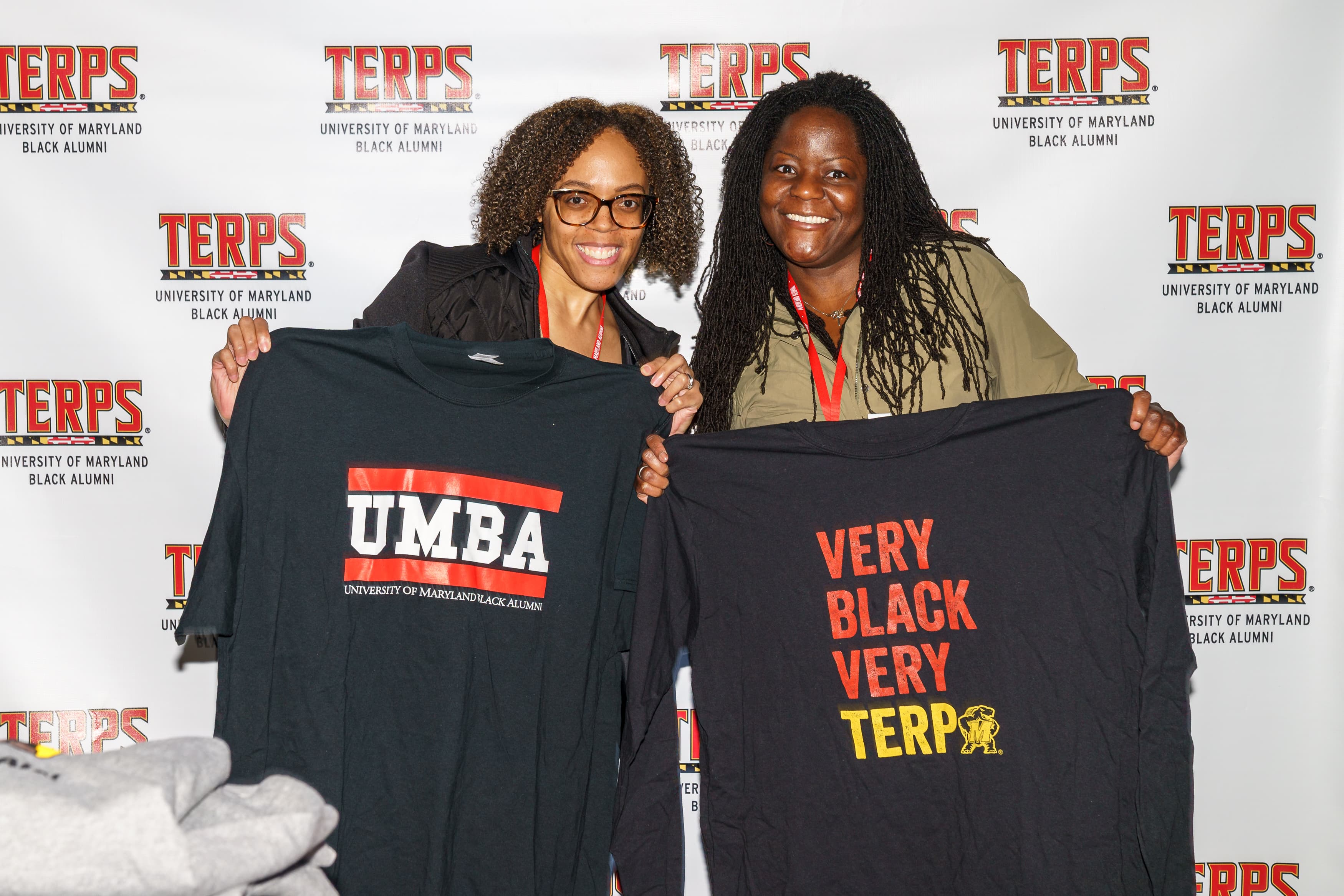 One person posing with an "UMBA" t-shirt, another posing with a "Very Black, Very Terp" shirt.
