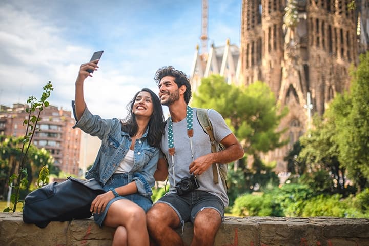 View of a couple taking a photo in front of La Sagrada Familia in Barcelona