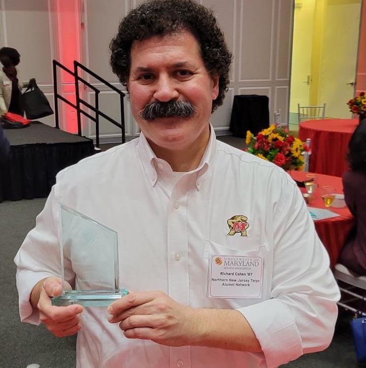 Rich Cohen '87 proudly holding their Volunteer of the year crystal award.