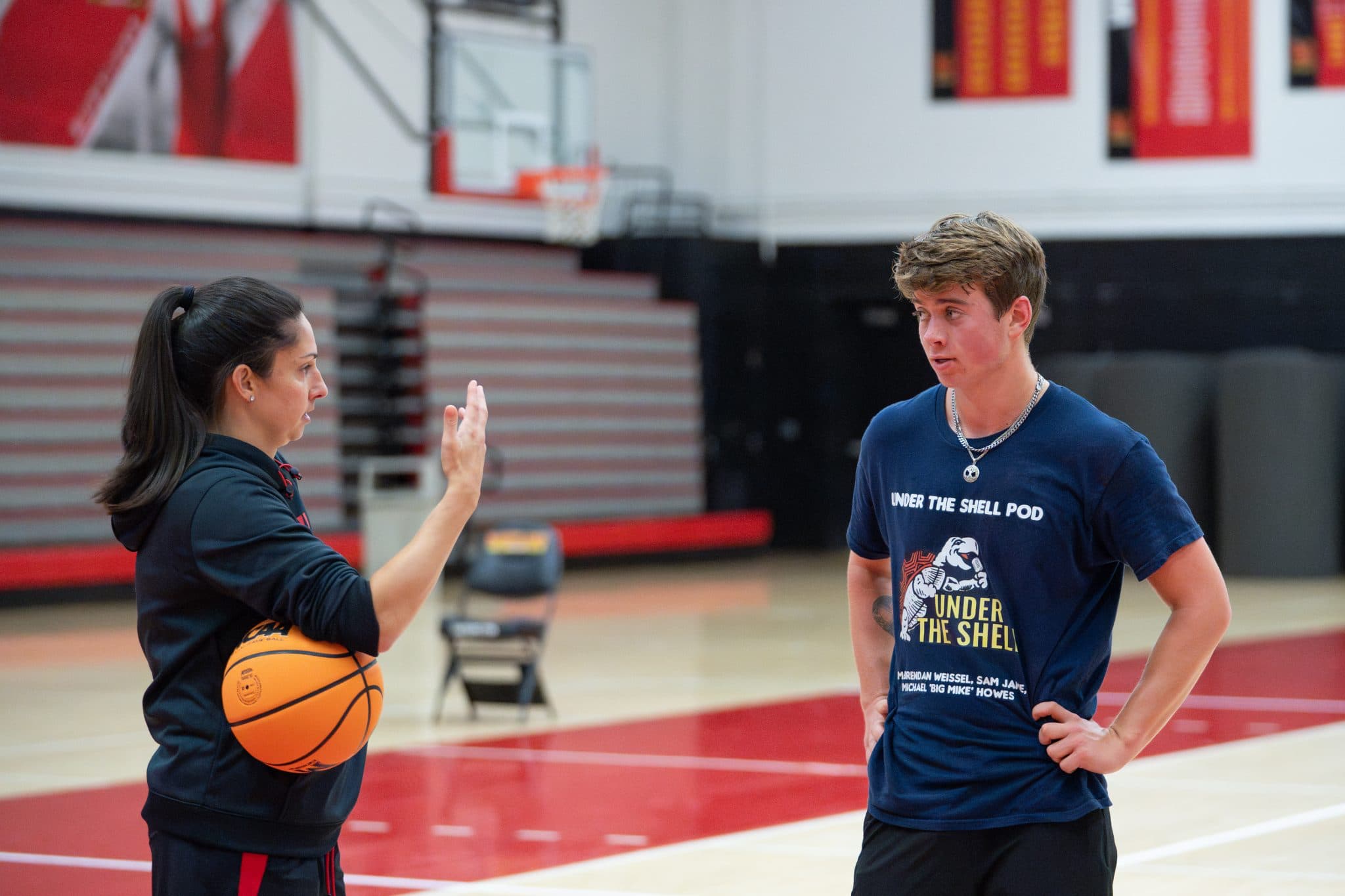 Sam Jane ’26 walking through drill instructions with Maryland women's basketball's assistant coach Jessica Imhof.