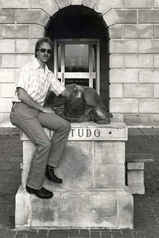 Dr. Rocky Lopes '80 sitting on a Testudo statue