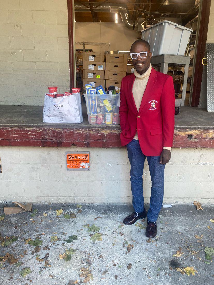 Rick Marving Tamno standing with some canned food he collected as part of his project "Give Thanks, Give Back."