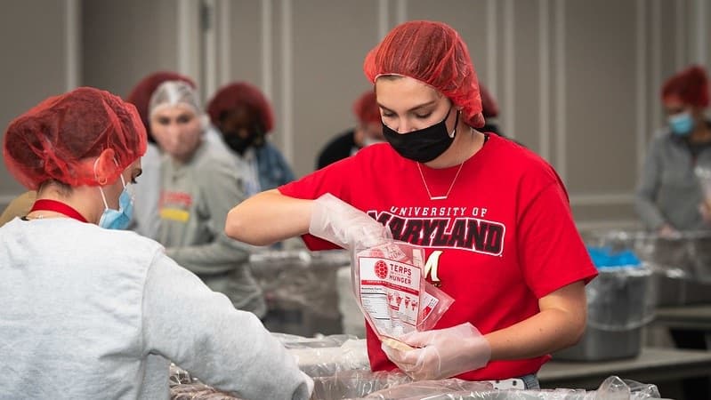 Terps volunteer at an event packaging food for others