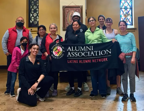 Latinx Alumni Network members holding up a UMD Alumni Association Banner